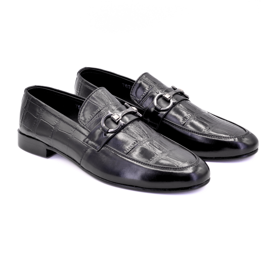 Pair of black leather loafers with a silver buckle on a white background