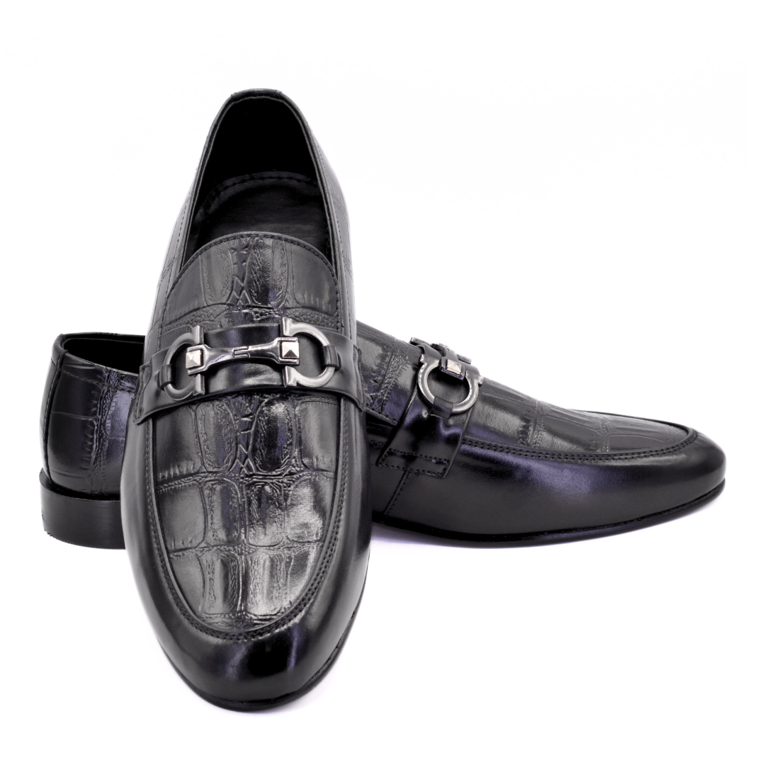 Black leather loafers with silver buckle on a white background