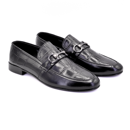 Pair of black leather loafers with a silver buckle on a white background