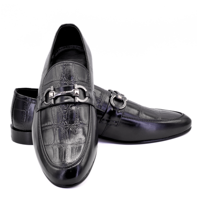 Black leather loafers with silver buckle on a white background