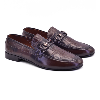 Pair of brown leather loafers with a copper buckle on a white background